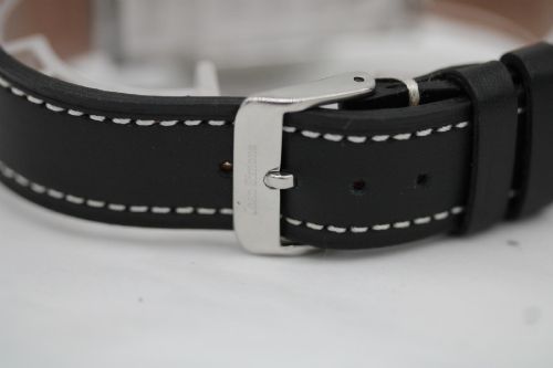 fig 6. A vintage Bulova automatic wristwatch featuring a black dial with silver baton hour markers and a black leather strap with white stitching.