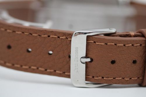fig 3. A 1967 stainless steel Omega wristwatch featuring a white dial with black Arabic numerals and a tan brown leather strap.