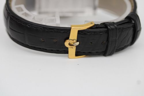 fig 2. A vintage gold-plated Omega Seamaster DeVille automatic wristwatch with a white textured dial, gold baton indices, date window, and black leather strap.