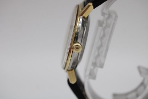 fig 8. A vintage gold-plated Omega Seamaster DeVille automatic wristwatch with a white textured dial, gold baton indices, date window, and black leather strap.