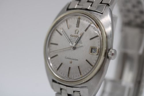 fig 5. A 1969 vintage Omega Constellation wristwatch featuring a stainless steel case, fluted bezel, silver linen dial, date window, and steel link bracelet.