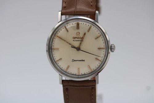 fig 2. A vintage 1961 Omega Seamaster wristwatch with a stainless steel case, silver dial, applied baton hour markers, and a tan leather strap.