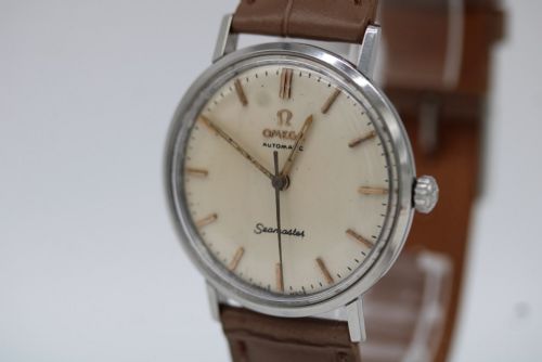 fig 3. A vintage 1961 Omega Seamaster wristwatch with a stainless steel case, silver dial, applied baton hour markers, and a tan leather strap.