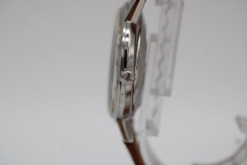 fig 8. A vintage 1961 Omega Seamaster wristwatch with a stainless steel case, silver dial, applied baton hour markers, and a tan leather strap.