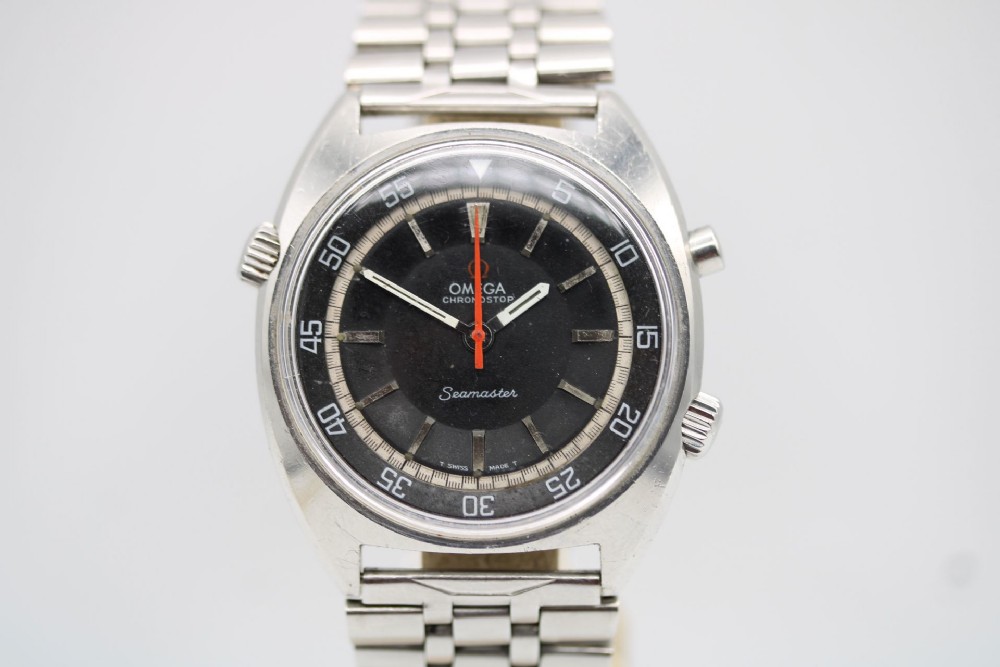 A 1968 stainless steel Omega Seamaster Chronostop wristwatch with a black dial, inner rotating bezel, and central orange hand.