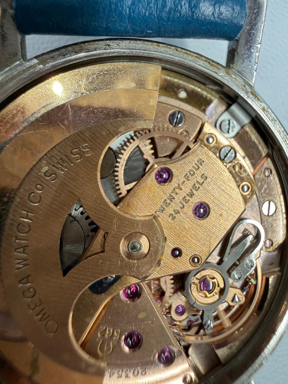 A 1963 stainless steel Omega Seamaster automatic wrist watch featuring a silver dial with baton indices, date window at three oclock, and a blue leather strap. View IV