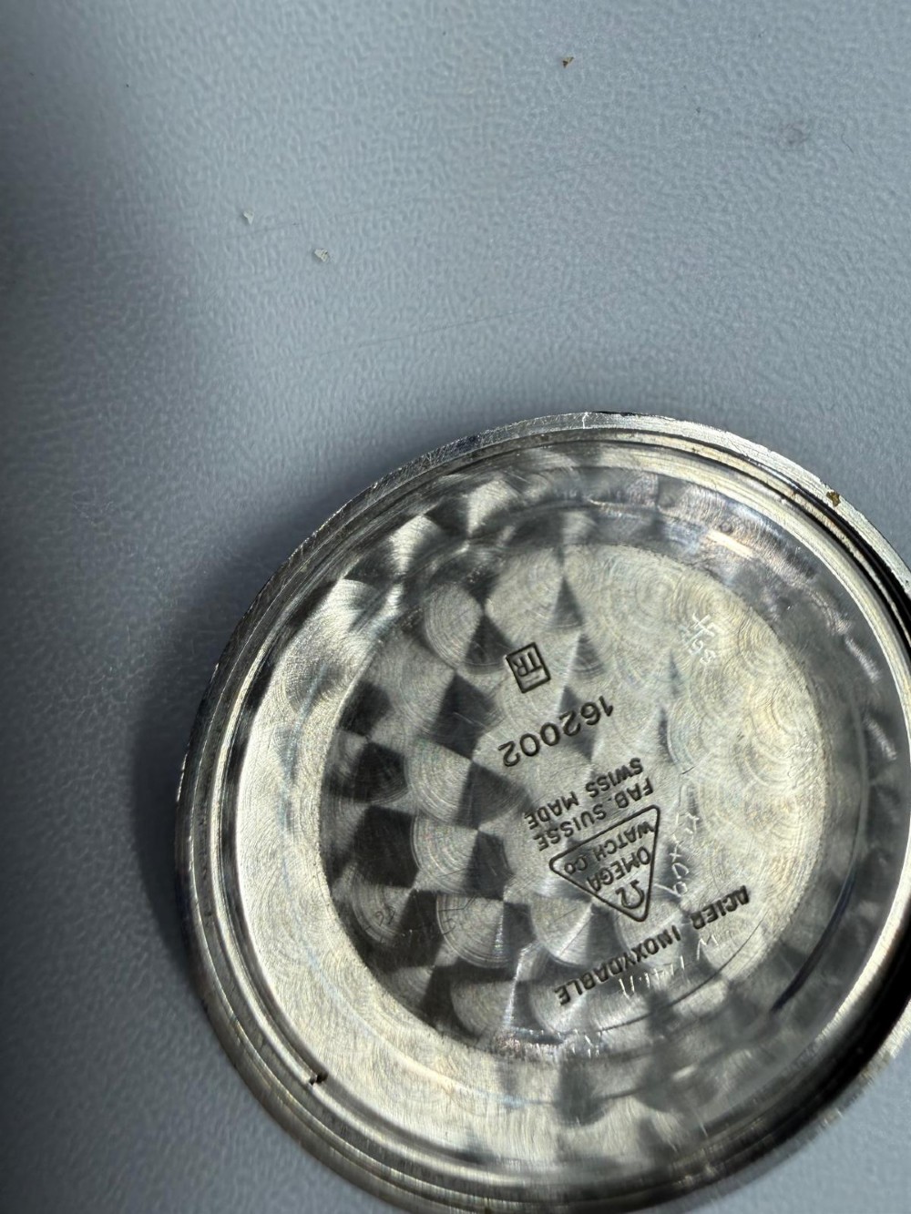 A 1963 stainless steel Omega Seamaster automatic wrist watch featuring a silver dial with baton indices, date window at three oclock, and a blue leather strap. View V