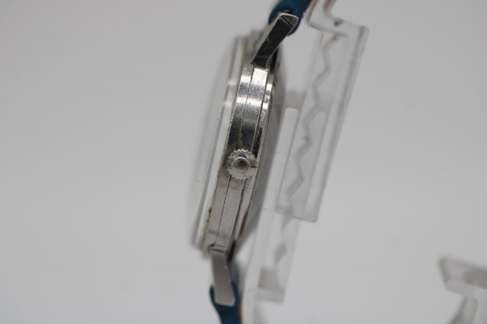 A 1963 stainless steel Omega Seamaster automatic wrist watch featuring a silver dial with baton indices, date window at three oclock, and a blue leather strap. View VI