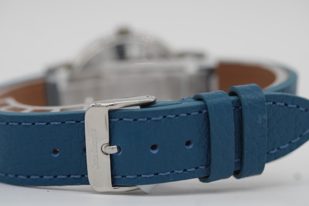 A 1963 stainless steel Omega Seamaster automatic wrist watch featuring a silver dial with baton indices, date window at three oclock, and a blue leather strap. View IX
