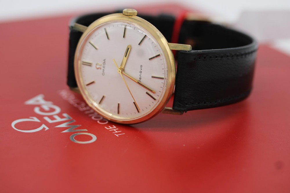A 1963 stainless steel Omega Seamaster automatic wrist watch featuring a silver dial with baton indices, date window at three oclock, and a blue leather strap. View XI