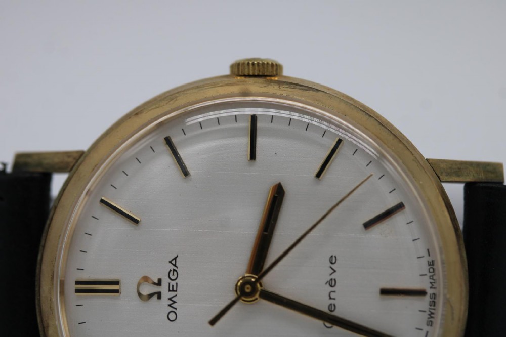 A 1963 stainless steel Omega Seamaster automatic wrist watch featuring a silver dial with baton indices, date window at three oclock, and a blue leather strap. View XII