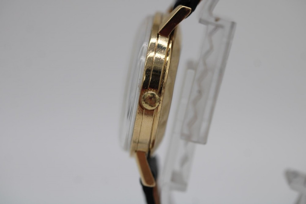 A 1962 Omega automatic wristwatch featuring a round 9ct gold case, silver dial with baton indices, and a blue textured leather strap. View II