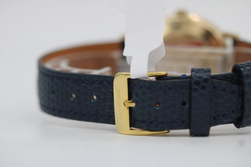 A 1962 Omega automatic wristwatch featuring a round 9ct gold case, silver dial with baton indices, and a blue textured leather strap. View VIII