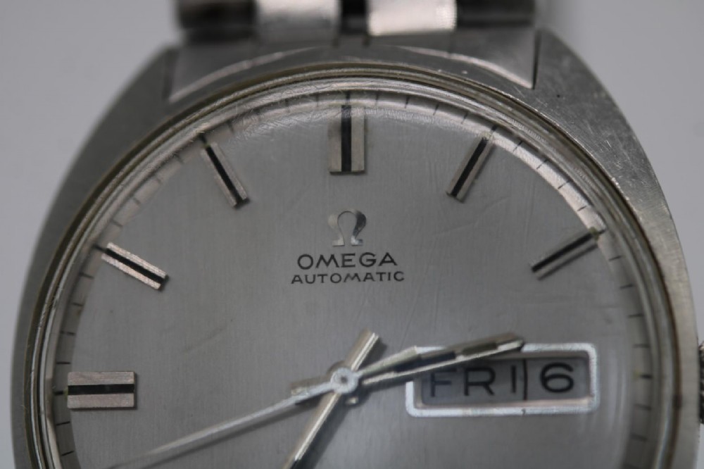 A vintage stainless steel Omega Seamaster Cosmic wristwatch featuring a silver dial with day-date window and metallic link bracelet. View II