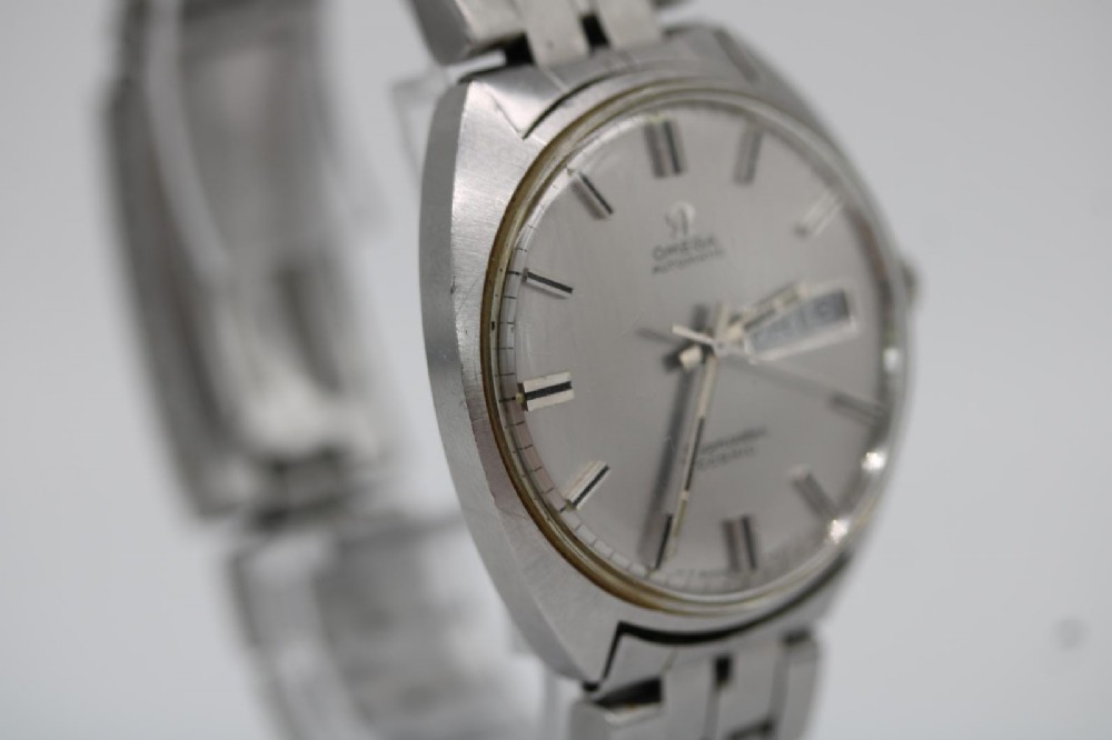 A vintage stainless steel Omega Seamaster Cosmic wristwatch featuring a silver dial with day-date window and metallic link bracelet. View III