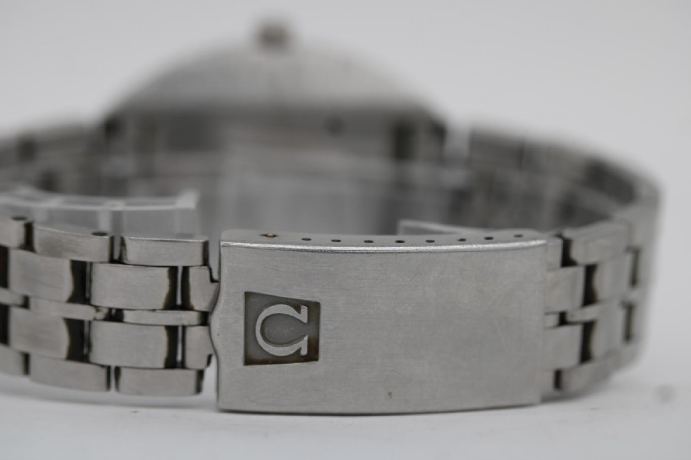 A vintage stainless steel Omega Seamaster Cosmic wristwatch featuring a silver dial with day-date window and metallic link bracelet. View V