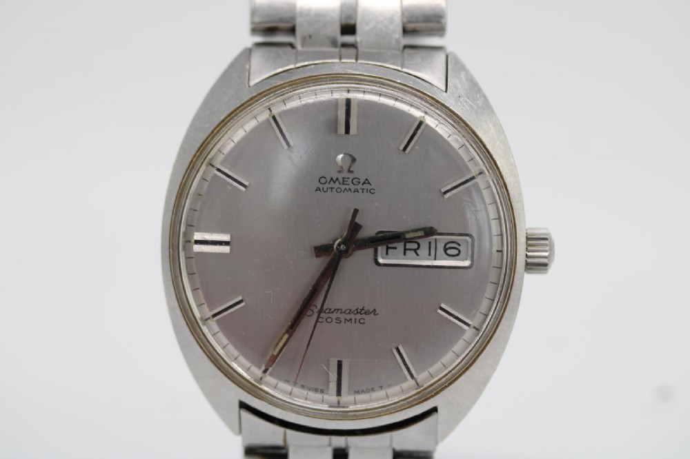 A vintage stainless steel Omega Seamaster Cosmic wristwatch featuring a silver dial with day-date window and metallic link bracelet. View VII