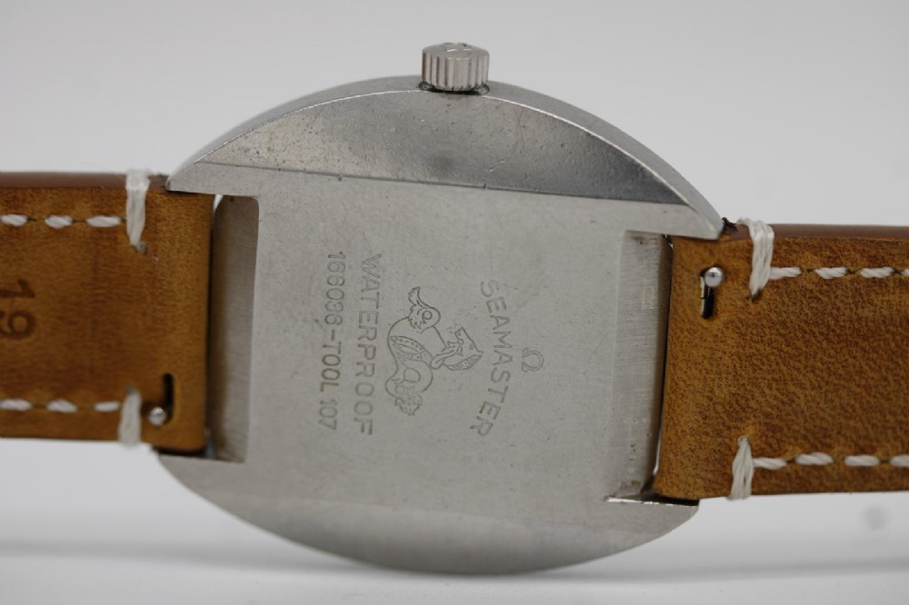 A vintage stainless steel Omega Seamaster Cosmic automatic wristwatch featuring a silver dial with day-date aperture and a tan leather strap with white stitching. View V
