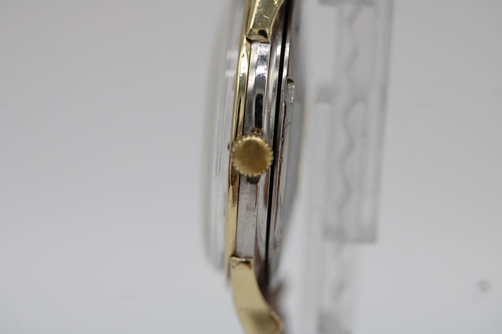 A vintage gold-plated Omega Constellation wristwatch featuring a faceted pie-pan dial, date window, and a brown leather strap. View IV