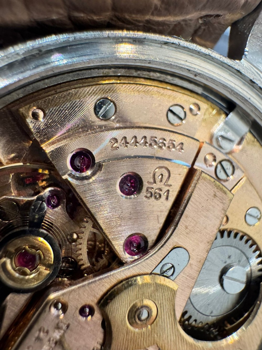 A vintage gold-plated Omega Constellation wristwatch featuring a faceted pie-pan dial, date window, and a brown leather strap. View IX