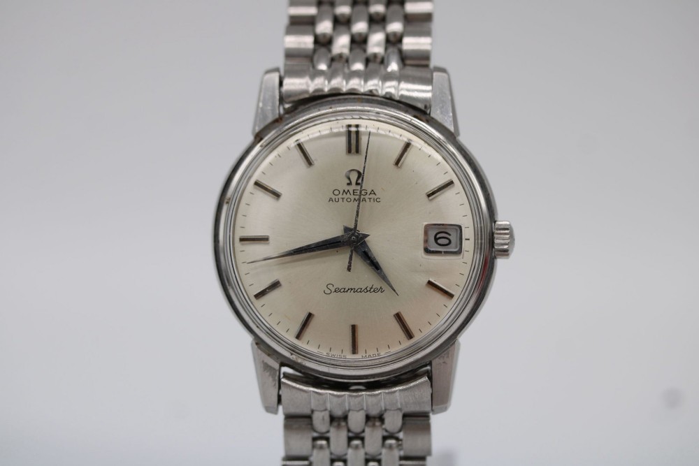 A vintage stainless steel Omega Seamaster automatic wristwatch with a silver dial and a beads-of-rice metal bracelet.