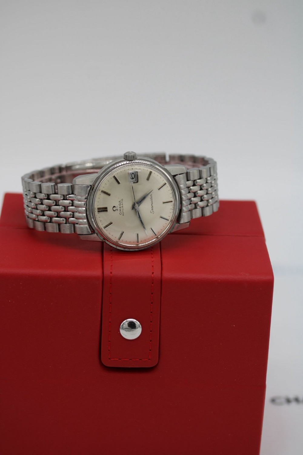 A vintage stainless steel Omega Seamaster automatic wristwatch with a silver dial and a beads-of-rice metal bracelet. View X