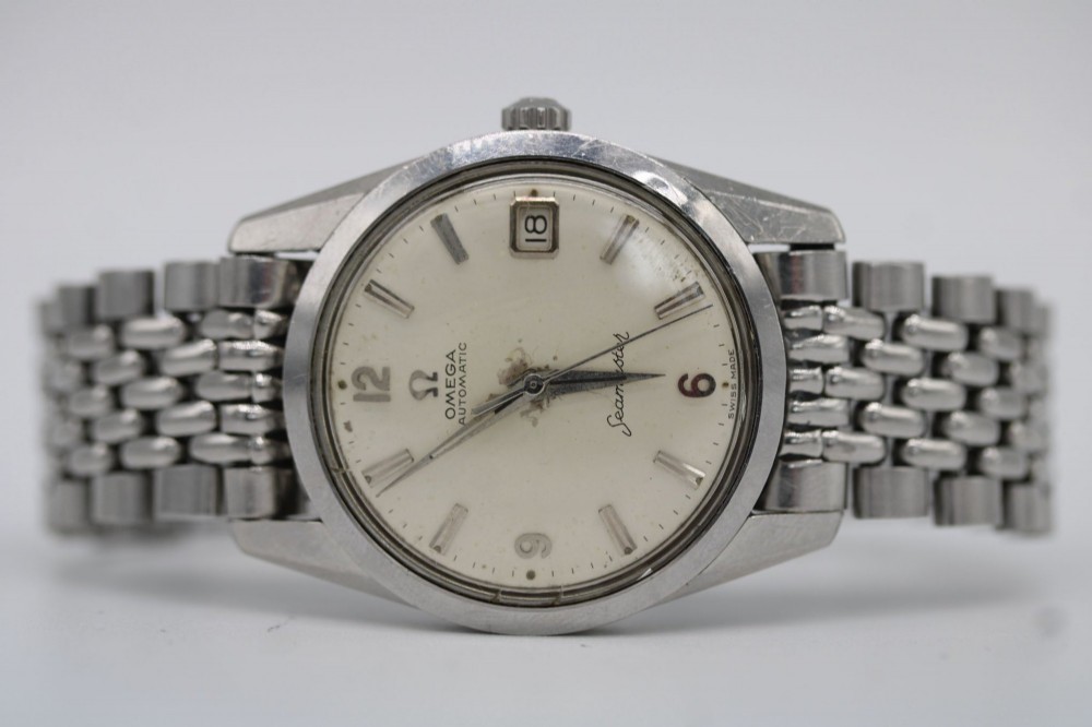 A 1960s stainless steel Omega Seamaster wristwatch with a patinated cream dial and a beads-of-rice bracelet. View V