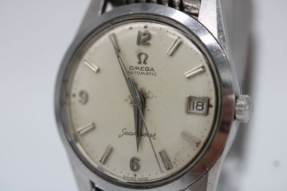 A 1960s stainless steel Omega Seamaster wristwatch with a patinated cream dial and a beads-of-rice bracelet. View X