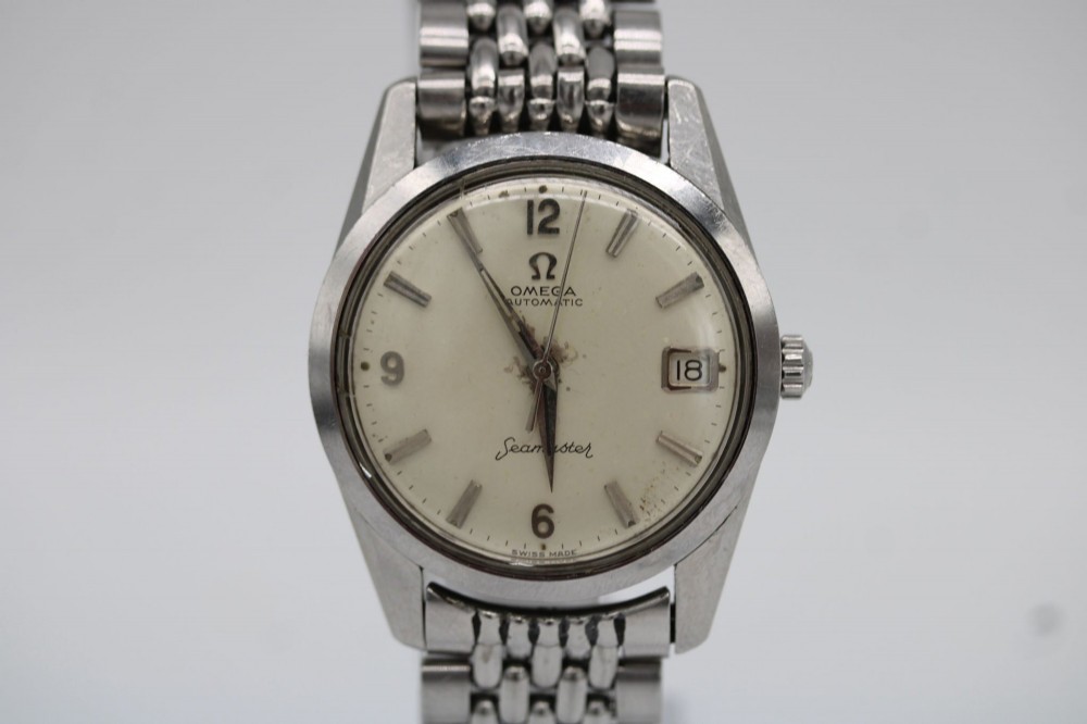 A 1960s stainless steel Omega Seamaster wristwatch with a patinated cream dial and a beads-of-rice bracelet. View XI