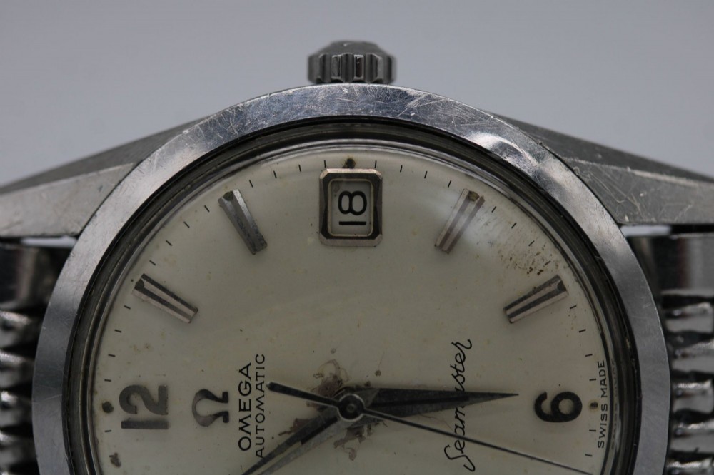 A 1960s stainless steel Omega Seamaster wristwatch with a patinated cream dial and a beads-of-rice bracelet. View XII