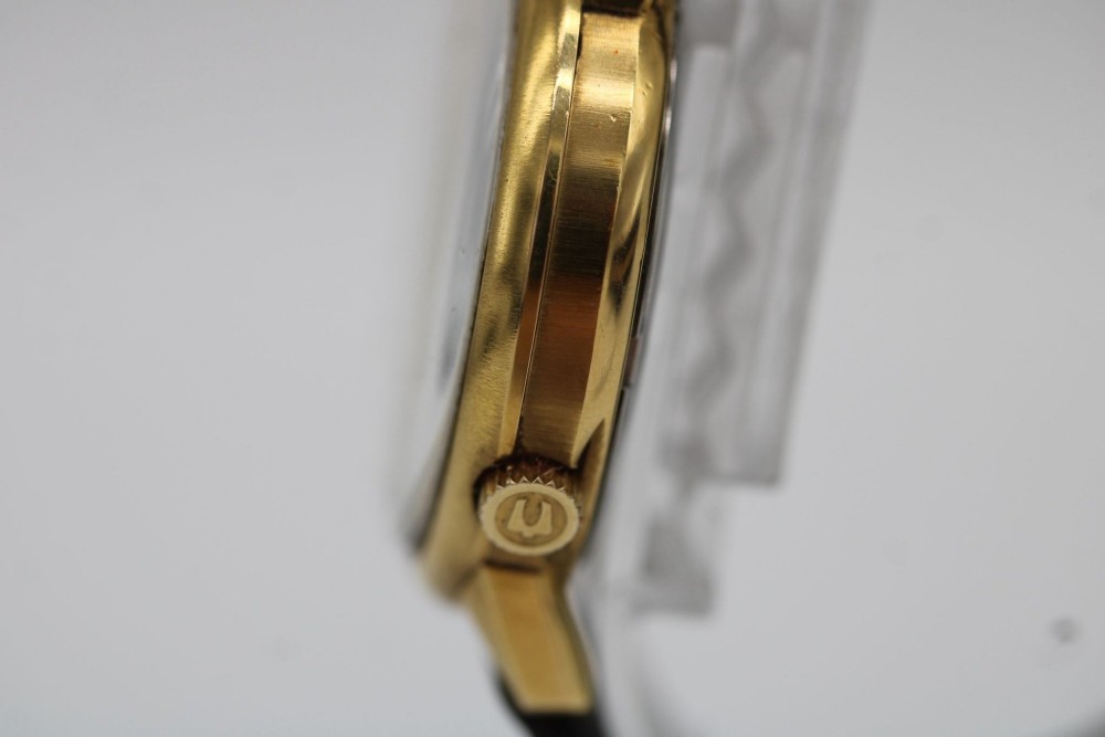 A 1960s circular gold-plated Bulova Accutron wristwatch with a grey-brown dial, date display, and brown leather strap. View VIII