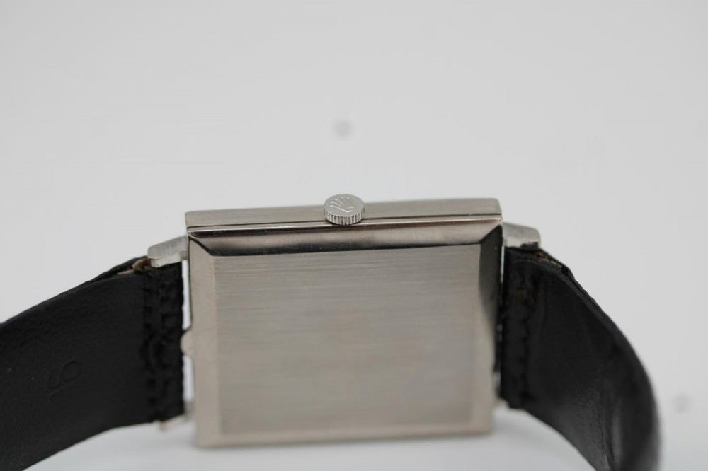 A 1960s square Rolex Cellini wristwatch featuring an 18ct white gold case, silver sunburst dial with simple index markers, and a black textured leather strap. View II