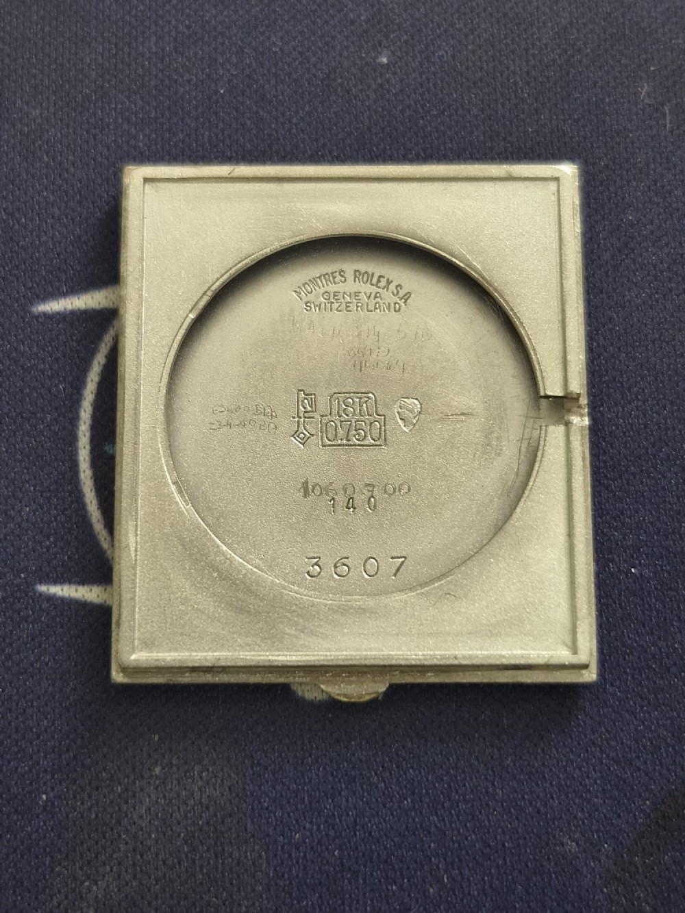 A 1960s square Rolex Cellini wristwatch featuring an 18ct white gold case, silver sunburst dial with simple index markers, and a black textured leather strap. View IV