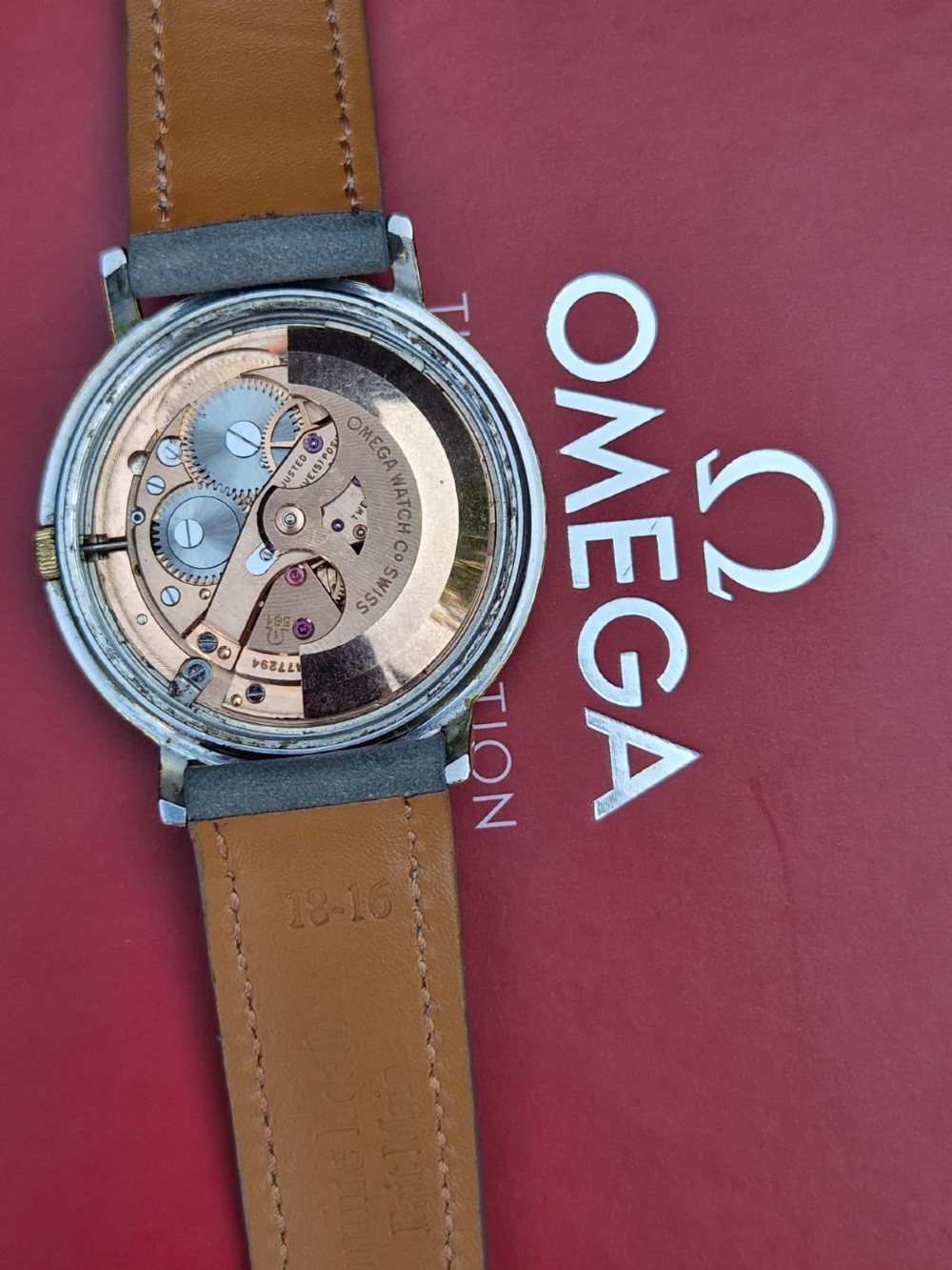 A vintage Omega Constellation wristwatch featuring a gold-plated circular case, silver-tone dial with date aperture, and a grey suede strap. View XIII