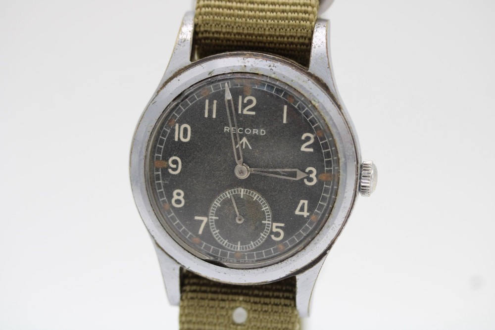 A 1940s Record military wristwatch with a black dial, Arabic numerals, broad arrow mark, and a khaki fabric strap.