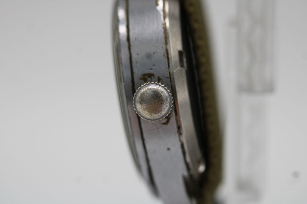 A 1940s Record military wristwatch with a black dial, Arabic numerals, broad arrow mark, and a khaki fabric strap. View X