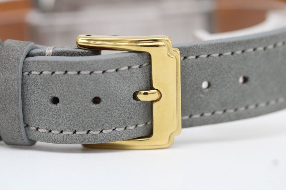 A circular 14ct gold vintage Omega Constellation wristwatch featuring a cream dial with gold baton markers, dauphine hands, date window, and a grey leather strap. View IV