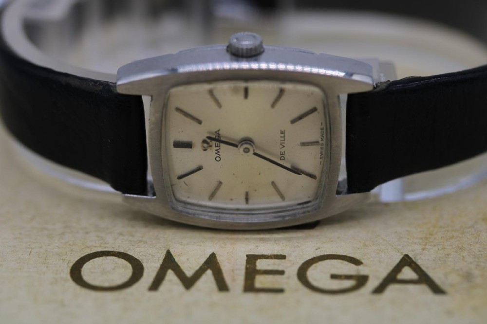 A vintage 1968 ladies Omega De Ville stainless steel wristwatch featuring a tonneau-shaped case, silvered dial, and black leather strap. View II