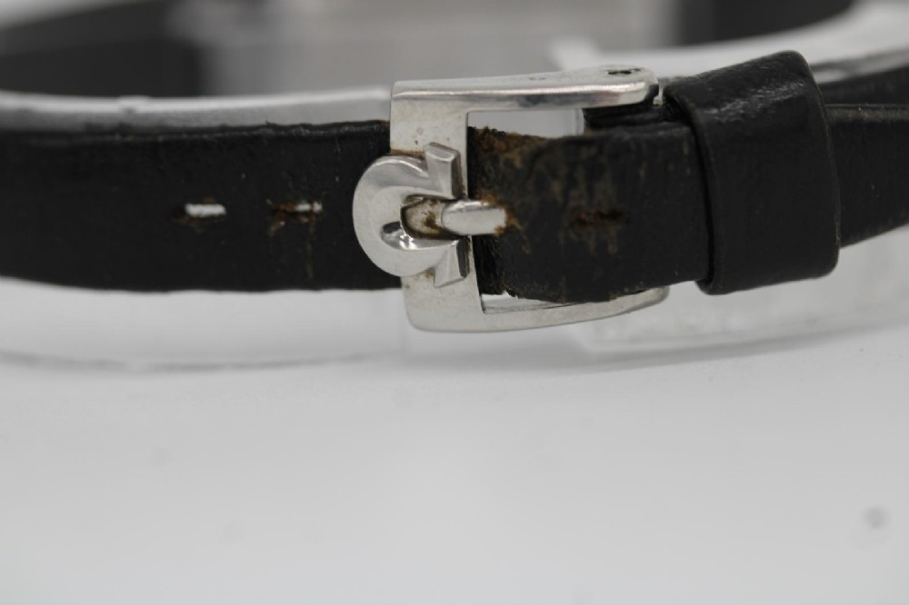 A vintage 1968 ladies Omega De Ville stainless steel wristwatch featuring a tonneau-shaped case, silvered dial, and black leather strap. View V