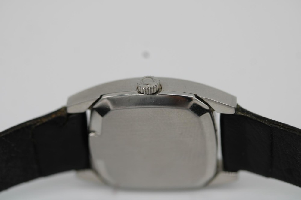 A vintage 1968 ladies Omega De Ville stainless steel wristwatch featuring a tonneau-shaped case, silvered dial, and black leather strap. View X