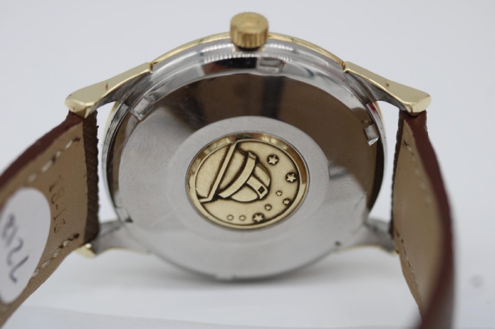 A 1962 vintage Omega Constellation wristwatch featuring a gold pie-pan dial, date aperture, and brown leather strap. View XIII