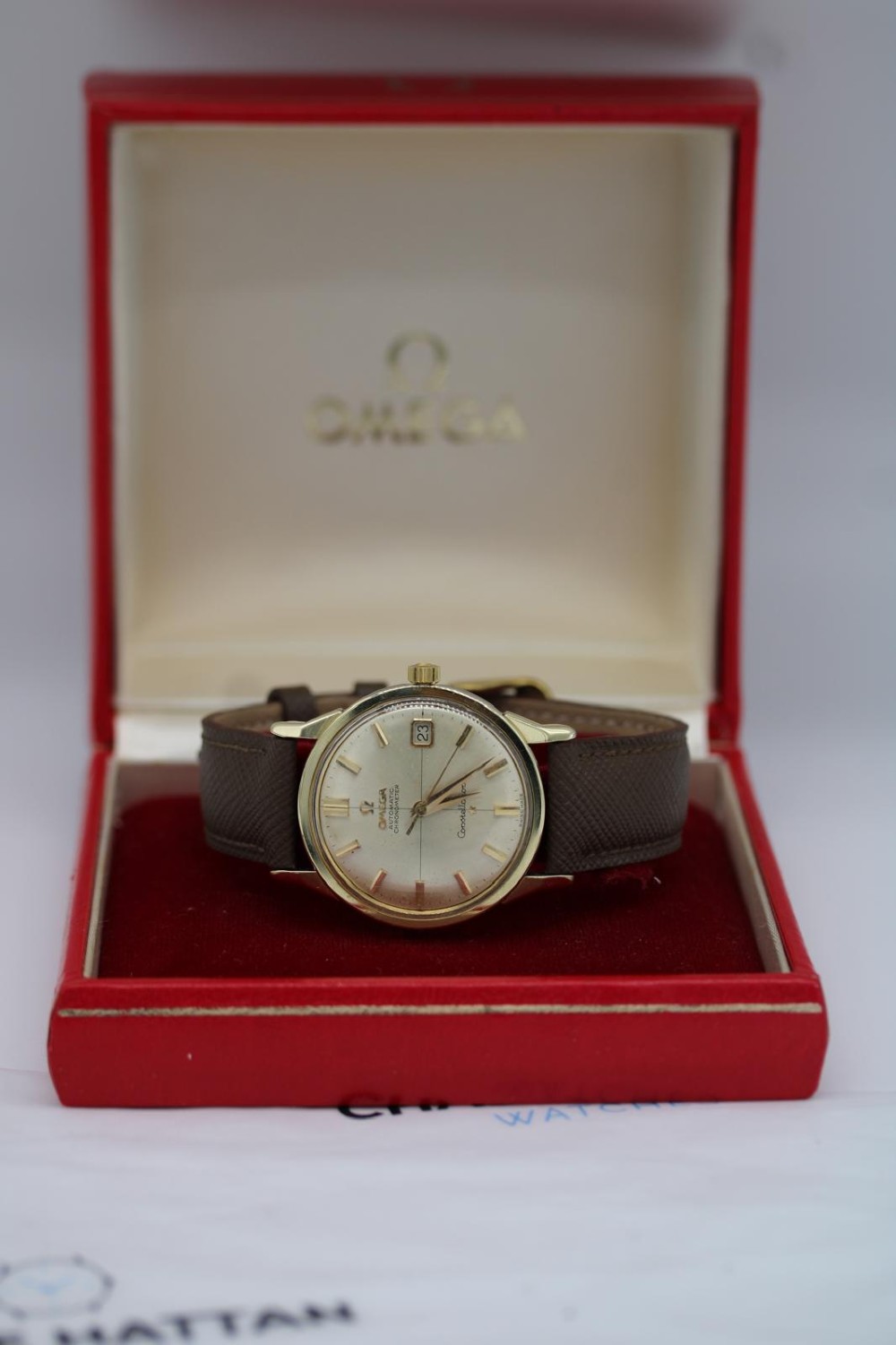 A 1962 vintage Omega Constellation wristwatch featuring a gold pie-pan dial, date aperture, and brown leather strap. View XV