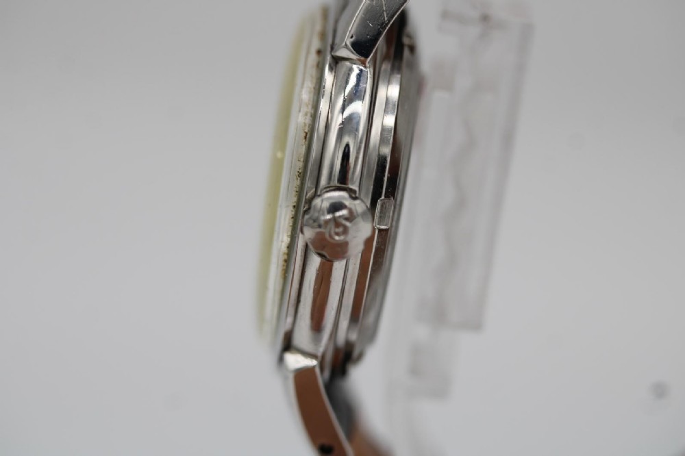 A vintage 1952 Omega Seamaster Calendar wristwatch featuring a stainless steel case, textured gold-coloured dial with date display at six oclock, and a black leather strap. View III