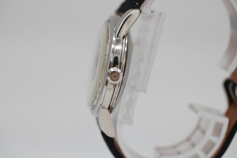 A 1950s stainless steel Omega Seamaster wristwatch featuring a patinated cream dial with silver baton indices and a black leather strap. View II