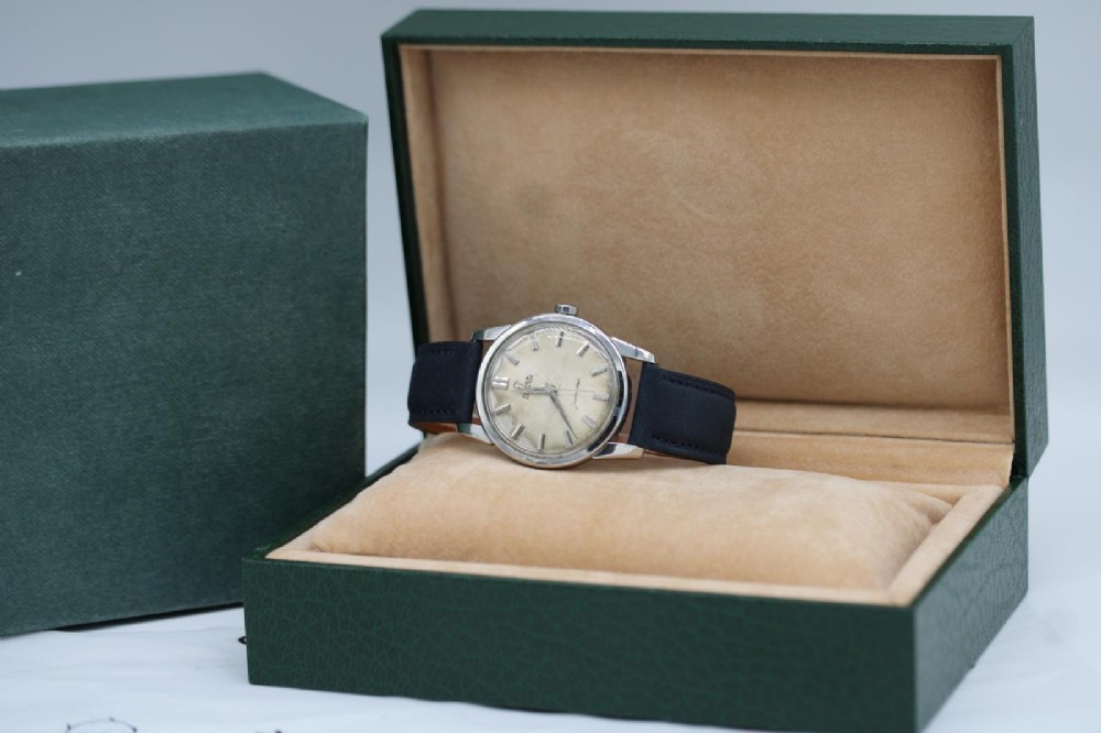A 1950s stainless steel Omega Seamaster wristwatch featuring a patinated cream dial with silver baton indices and a black leather strap. View VIII