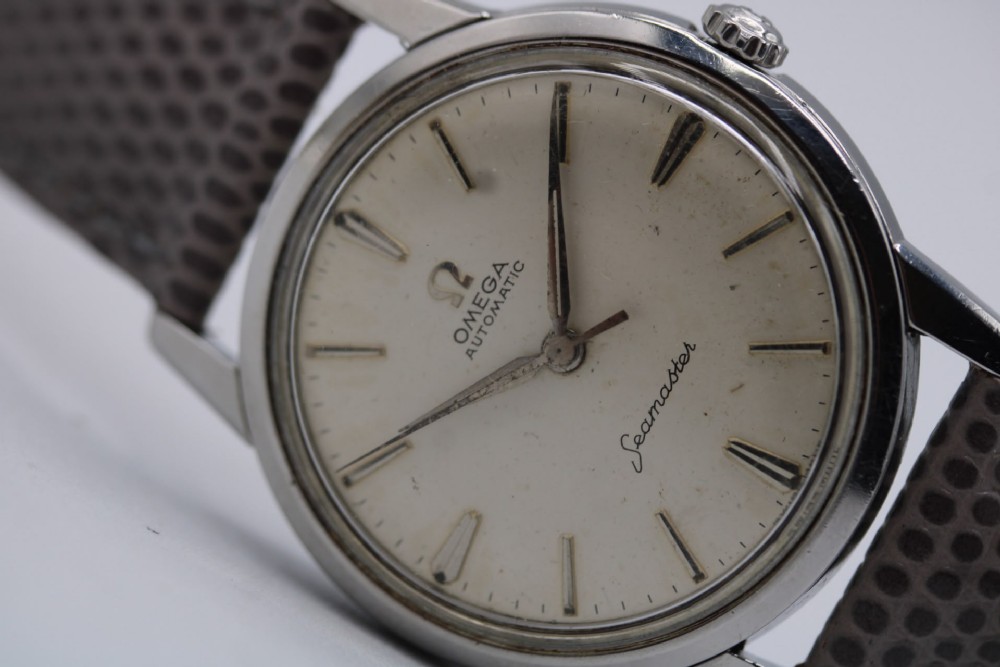 A vintage 1960 Omega Seamaster automatic wristwatch with a stainless steel case, silver cream dial, and grey textured leather strap. View III