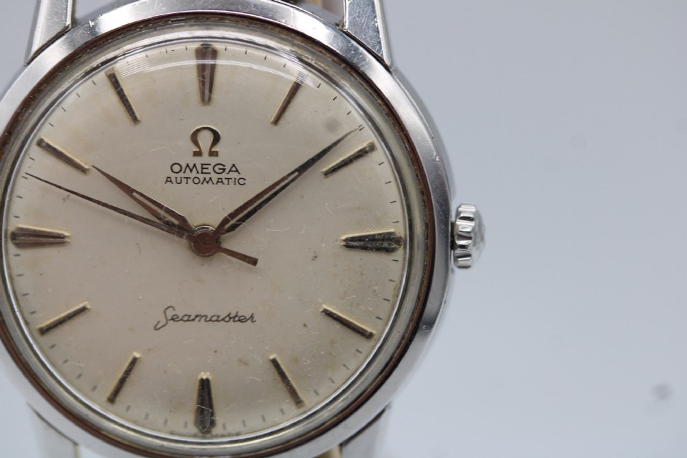 A vintage 1960 Omega Seamaster automatic wristwatch with a stainless steel case, silver cream dial, and grey textured leather strap. View VII