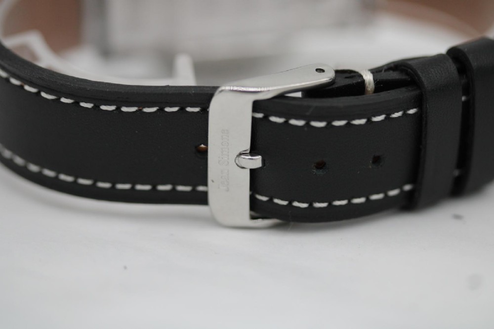 A vintage Bulova automatic wristwatch featuring a black dial with silver baton hour markers and a black leather strap with white stitching. View VII