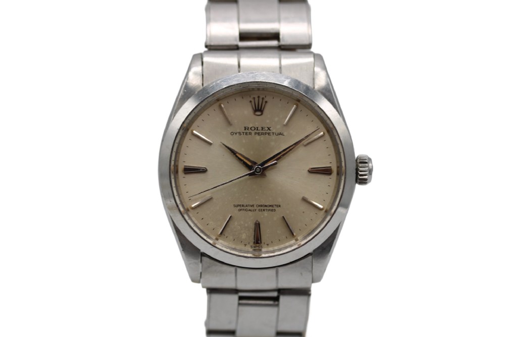 A stainless steel Rolex Oyster Perpetual wrist watch featuring a silver dial with baton indices and an integrated steel bracelet.
