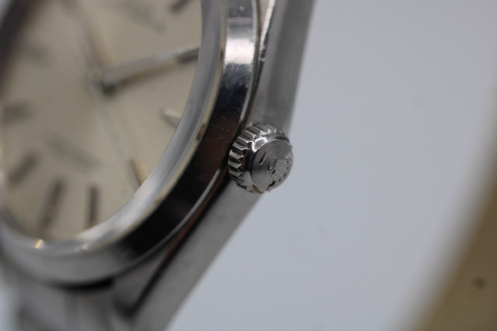 A stainless steel Rolex Oyster Perpetual wrist watch featuring a silver dial with baton indices and an integrated steel bracelet. View II